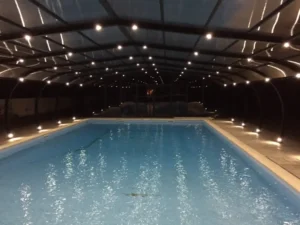 Piscine intérieure éclairée sous structure couverte la nuit
