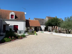 Cour intérieure de maison rurale aux volets rouges