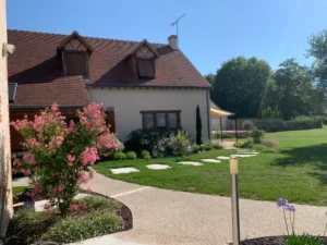 Maison avec jardin fleuri et pelouse ensoleillée