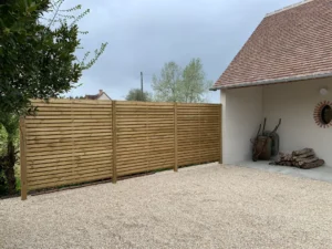 Clôture en bois dans cour gravillonnée