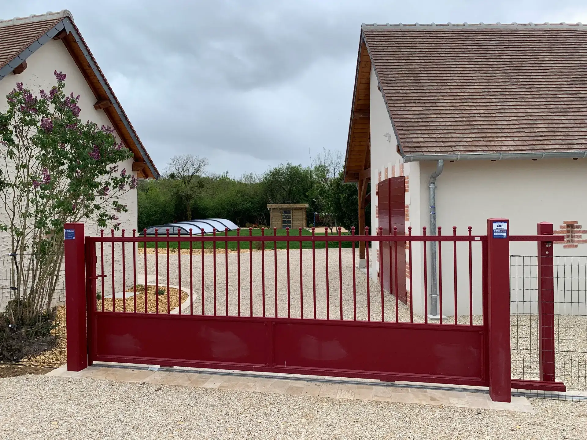 Portail coulissant rouge devant maison moderne