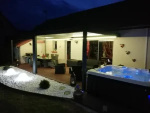 Terrasse couverte avec jacuzzi éclairé la nuit