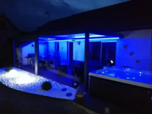 Terrasse moderne éclairée en bleu avec jacuzzi