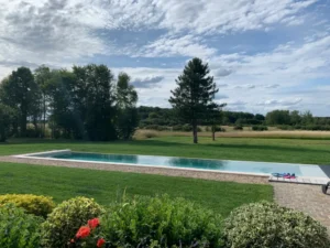 Piscine moderne dans grand jardin verdoyant