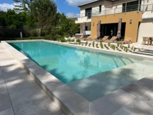 Piscine moderne devant maison contemporaine avec terrasse