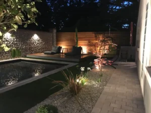 Jardin moderne avec piscine éclairée la nuit