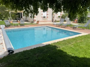 Piscine extérieure dans jardin avec transats