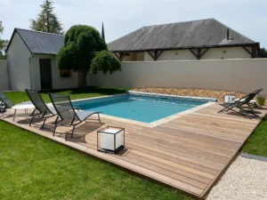 Piscine moderne avec terrasse en bois et transats