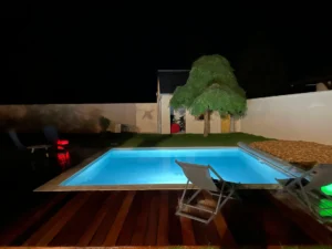 Piscine éclairée de nuit dans jardin moderne