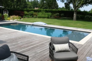 Piscine moderne avec terrasse en bois et jardin