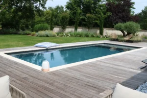 Piscine moderne avec terrasse en bois et jardin