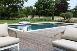 Piscine moderne avec terrasse en bois et jardin
