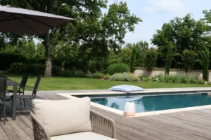 Piscine moderne dans jardin paysager avec terrasse en bois