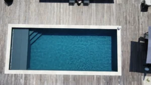 Piscine rectangulaire vue du dessus sur terrasse bois