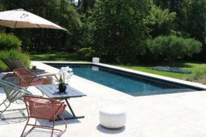 Piscine moderne dans jardin avec terrasse aménagée