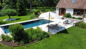 Piscine moderne dans jardin paysager avec maison