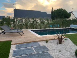 Piscine moderne avec terrasse en bois au coucher du soleil
