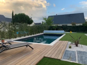 Piscine moderne avec terrasse en bois et jardin
