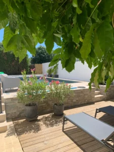 Terrasse en bois avec piscine et plantes fleuries