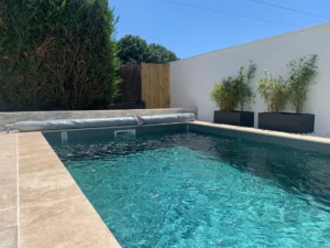Piscine moderne avec mur blanc et bambous