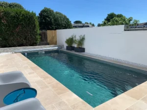 Piscine moderne étroite avec terrasse en pierre