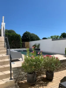 Piscine moderne avec terrasse et fleurs roses