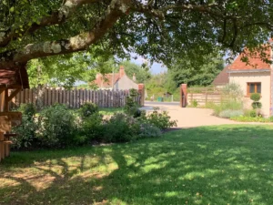 Jardin verdoyant avec maison et clôture en bois