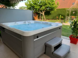 Spa extérieur sur terrasse dans jardin verdoyant