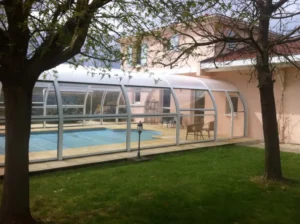 Piscine couverte dans jardin avec abri transparent