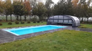 Piscine extérieure avec abri télescopique dans un jardin