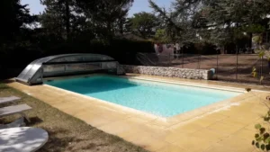 Piscine extérieure avec abri coulissant et terrasse