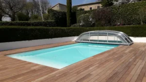 Piscine extérieure avec terrasse en bois et abri bas