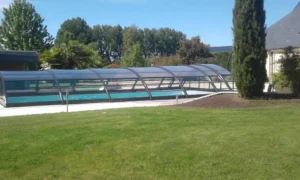 Piscine extérieure avec abri télescopique dans jardin