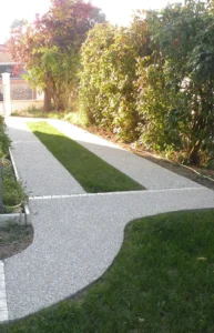 Allée de jardin en béton bordée de haies