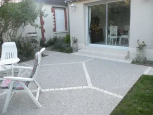 Terrasse moderne avec porte-fenêtre et chaises blanches