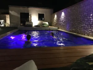 Piscine éclairée de nuit avec quatre baigneurs