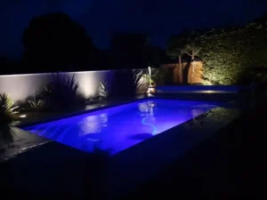 Piscine moderne éclairée en bleu la nuit