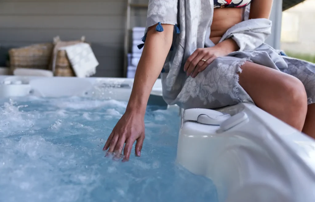 Femme assise au bord d’un jacuzzi bouillonnant
