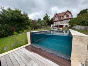 Piscine moderne avec paroi vitrée et maison