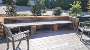 Banc d’angle en brique sur terrasse en bois