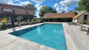 Piscine extérieure avec maison de campagne et terrasse