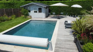 Piscine moderne avec terrasse et abri de jardin