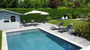 Piscine moderne avec terrasse et transats au jardin