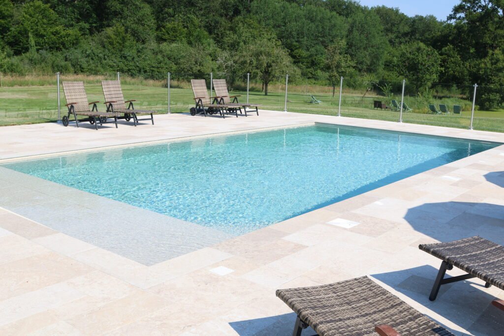 Piscine extérieure moderne avec transats et jardin verdoyant