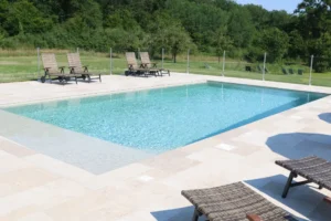 Piscine extérieure avec transats et jardin verdoyant