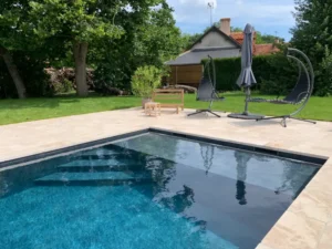 Piscine moderne dans jardin avec transats et parasol