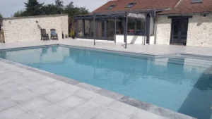 Piscine moderne devant maison en pierre