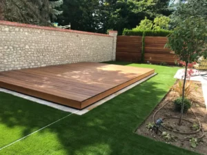 Terrasse en bois sur pelouse dans jardin aménagé