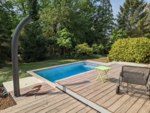Piscine extérieure sur terrasse en bois entourée d’arbres