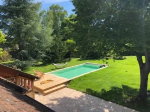Piscine rectangulaire dans jardin verdoyant arboré